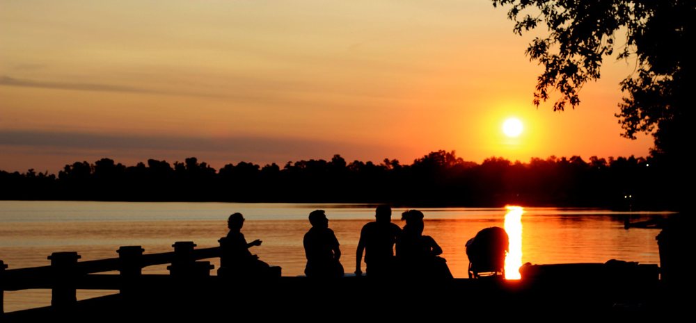Friends gathered by the lagoon as the sun goes down